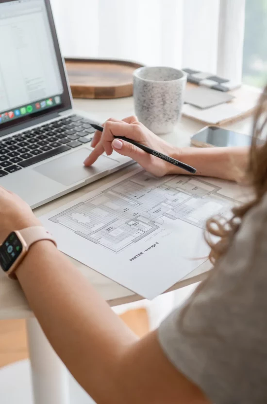 Architekta pracująca przy komputerze otoczona swoim kreatywnym chaosem